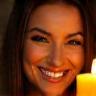 Lucía González, cliente, con sonrisa y una vela encendida