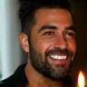 Miguel Álvarez, cliente satisfecho en casa con vela en la mano